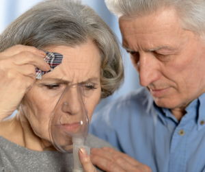 Pessoa idosa com alergia respiratória sendo acudida por parceiro idoso.